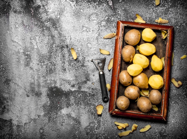 Photo fresh potatoes in an old tray on rustic table