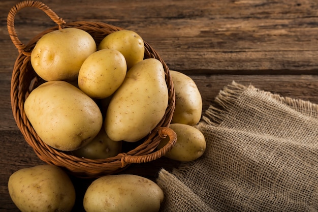 Fresh potatoes on the wooden table Raw potatoes