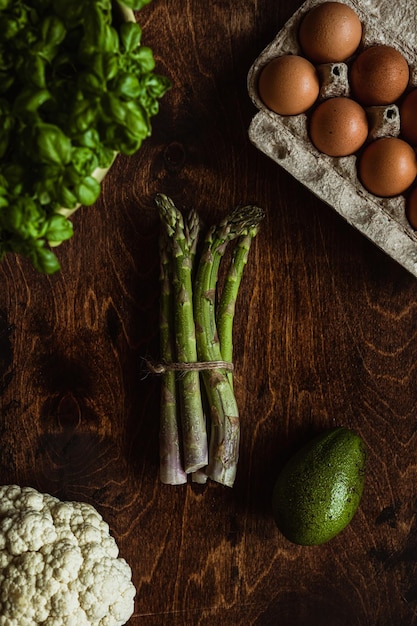 Fresh produce photography Vegetables on the wooden table Asparagus cauliflower eggs avocado basil