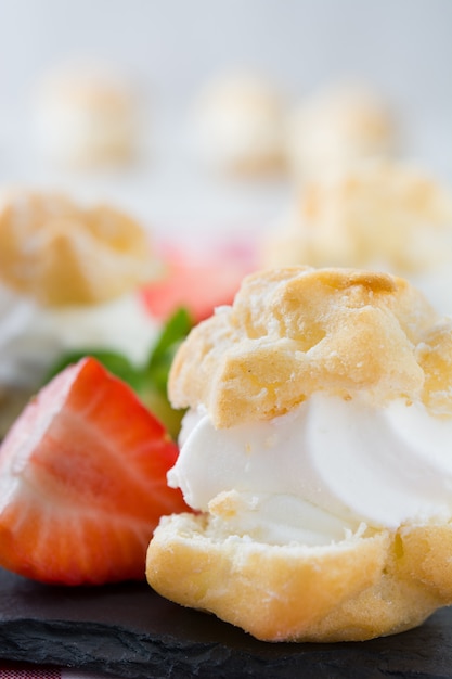 Fresh profiteroles with cream and strawberry