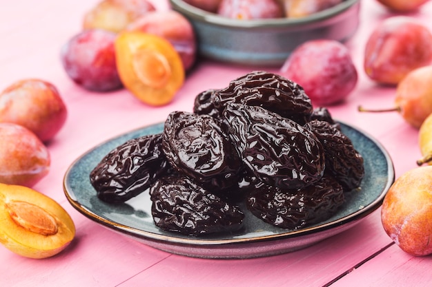 Fresh  prune and dried  prune on wooden board wall