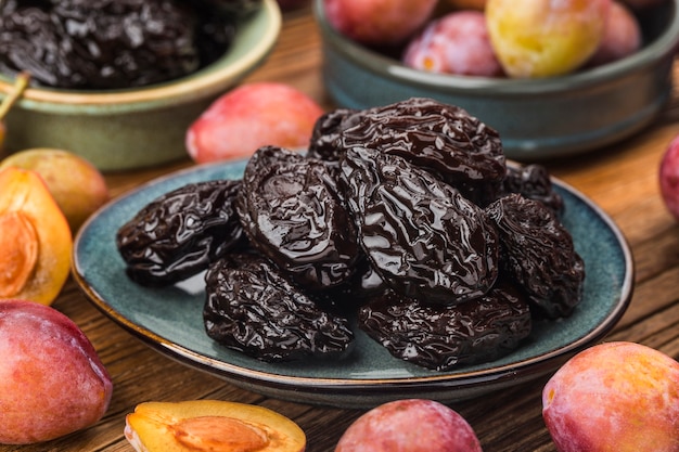 Fresh  prune and dried  prune on wooden board wall