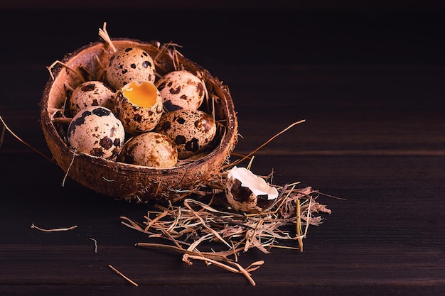 Fresh quail eggs in a plate of coconut on a wooden brown table top view vertical no people