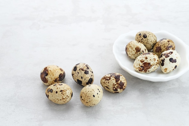 Fresh Quail Eggs served in bowl on grey background Space for text