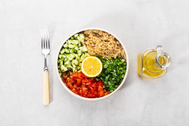 Fresh quinoa tabbouleh salad in a plate with  lemon and oil