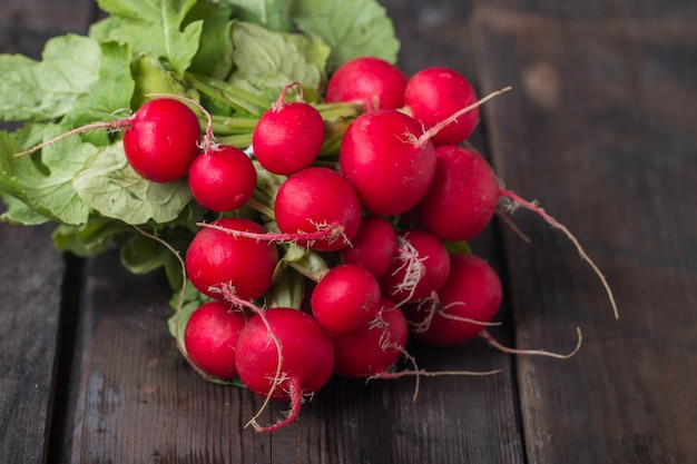 Fresh radishes on old wooden table