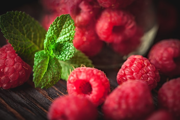 Fresh raspberries in a basket on a wooden table in the garden