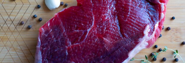 Fresh raw beef steak on wooden cutting board