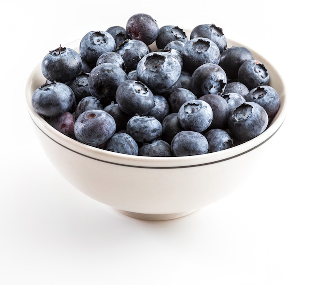 Fresh and raw blueberries with drops of water. In white bowl and ready to eat. Isolated with copy space.