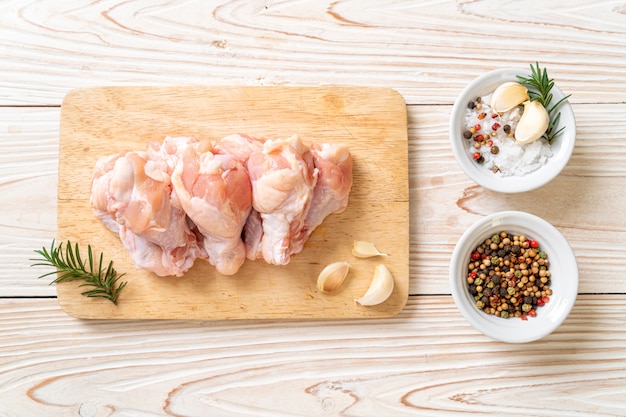 fresh raw chicken wings (drumette or drumstick) on wooden board