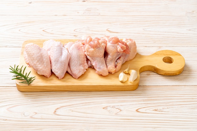 fresh raw chicken wings on wooden board