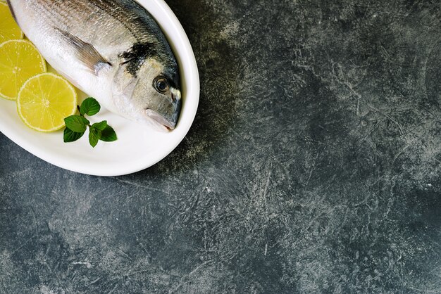 Photo fresh raw dorado fish with lime slices and mint leaves