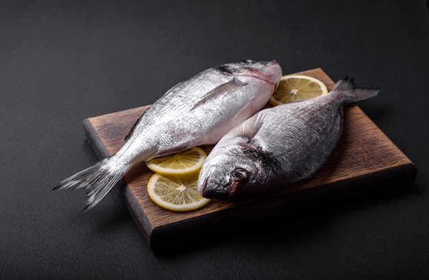 Fresh raw dorado fish with spices herbs salt and lemon