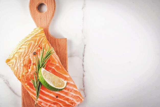 Fresh raw fish salmon, steak fillet, with spices, lime, rosemary, salt