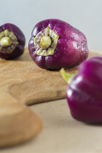 Fresh raw homemade purple pepper on a wooden kitchen board