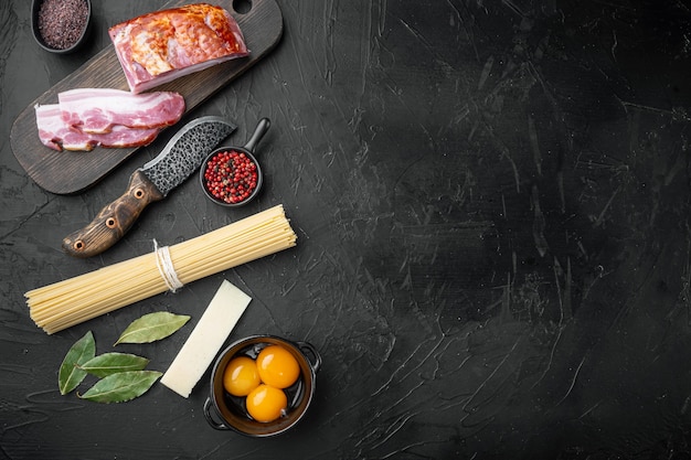 Fresh raw ingredients for traditional italian pasta Carbonara set, on black stone table, top view flat lay