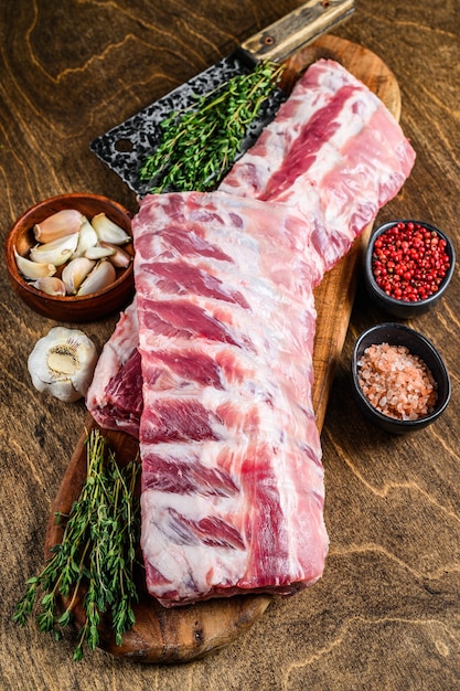 Fresh Raw lamb rack spare ribs with spices on a cutting board.