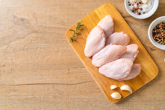 fresh raw middle chicken wings on wooden board