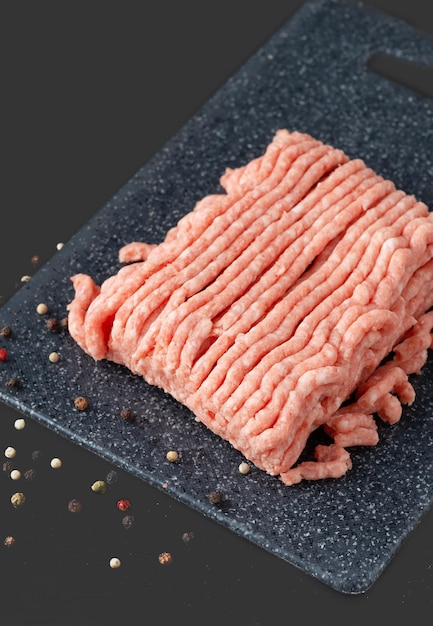 Fresh raw minced beef in a on a cutting board close up on a rustic table