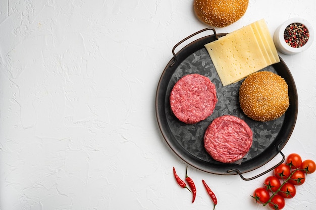 Fresh Raw Minced Homemade Grill Beef Steak Burgers on white stone table background top view flat lay with copy space for text