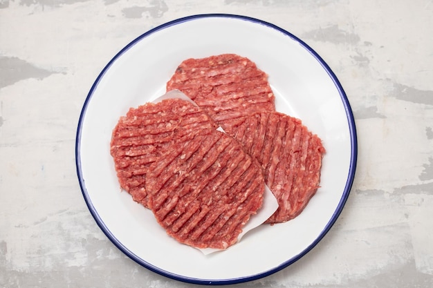 Fresh raw minced meat on white dish with paper