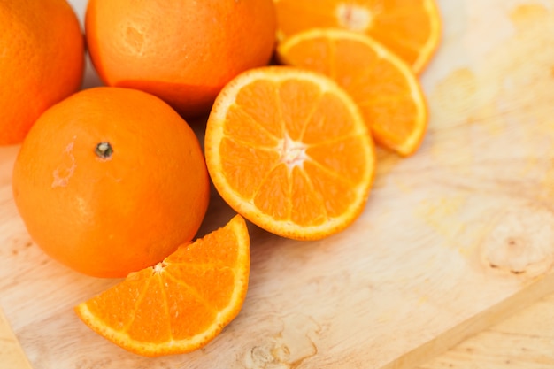 Fresh raw oranges on wood