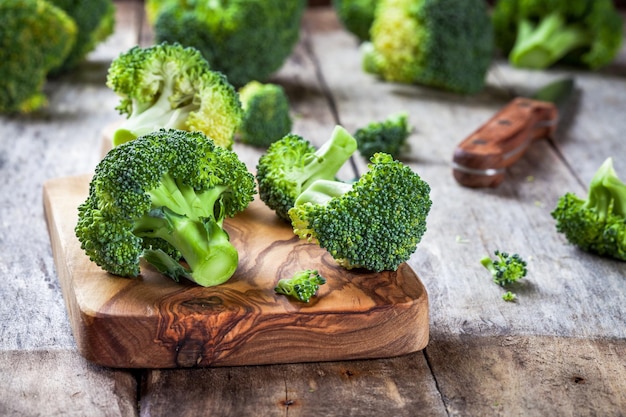 Fresh raw organic broccoli cutting board on a wooden background