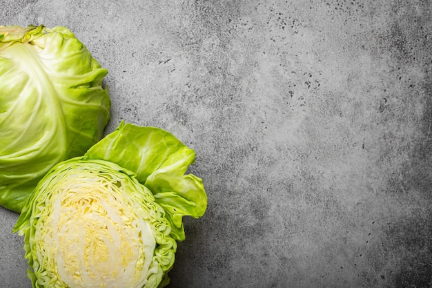 Fresh raw organic farm cabbage cut in half on grey rustic