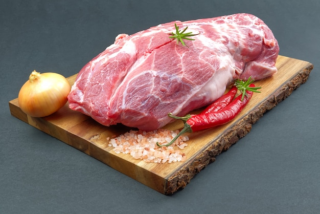 Fresh raw pork neck with spices on wooden board