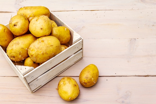 Fresh raw potatoes in wooden box