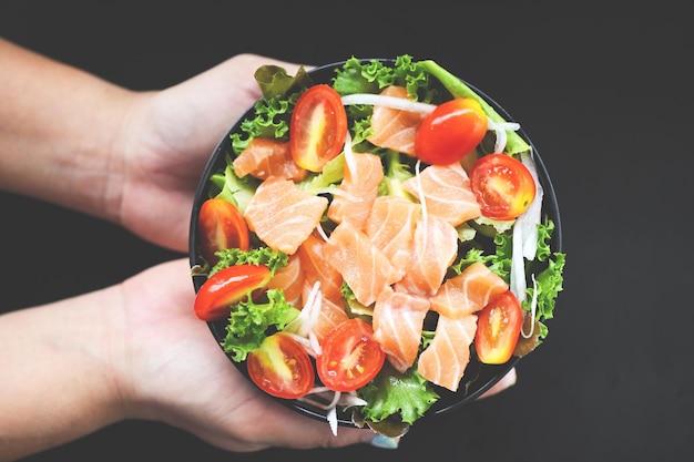 Fresh raw salmon fish cooking food seafood salmon fish healthy food on hand salmon salad food salmon fillet with vegetable lettuce leaf tomato herb and spices