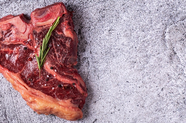 Fresh raw tbone steak on gray stone background