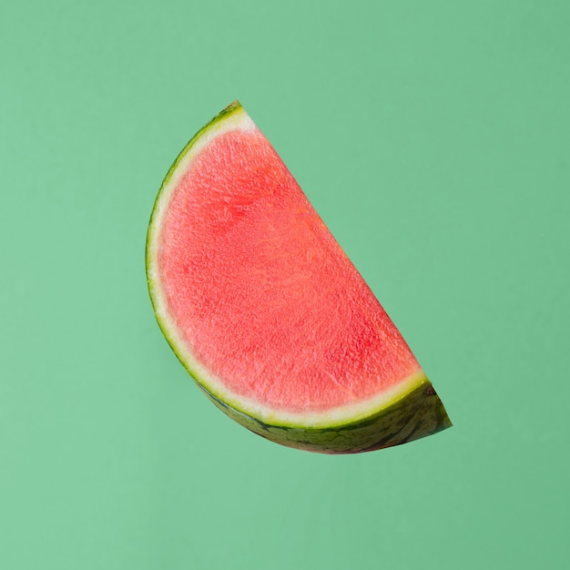 Fresh raw watermelon piece isolated on green background