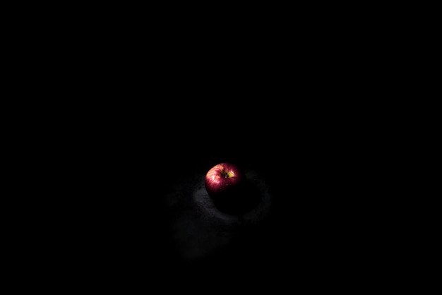 Fresh red apple On a black background with water droplets lights are falling with space for text