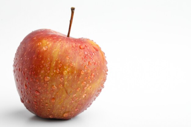 Fresh red apple with water drops isolated on white background.