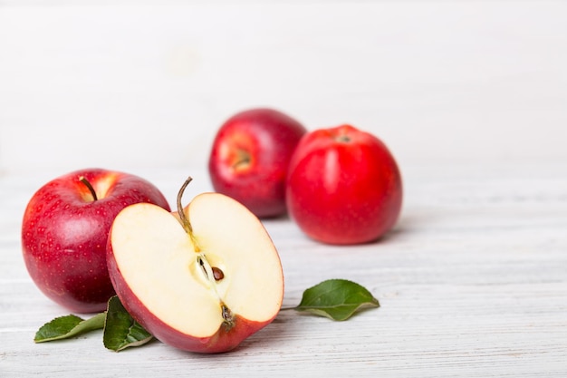 Fresh red apples with green leaves on wooden table. On wooden background. Top view free space for text