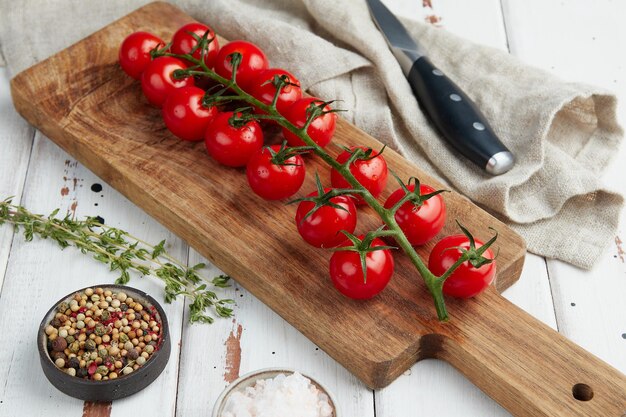 Fresh red cherry tomatoes on white wooden background