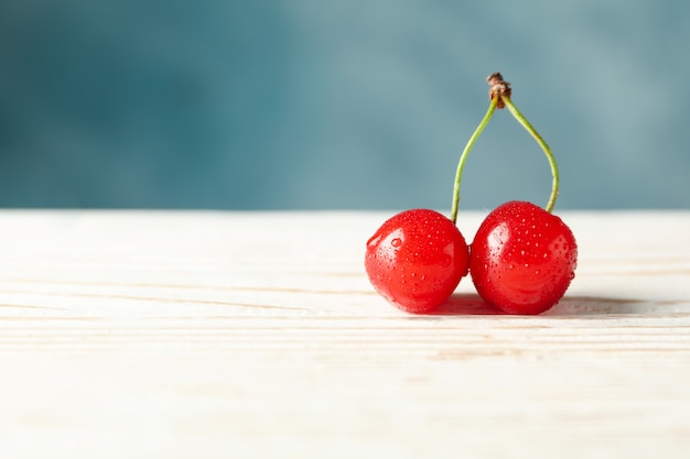 Fresh red cherry on wooden space, close up