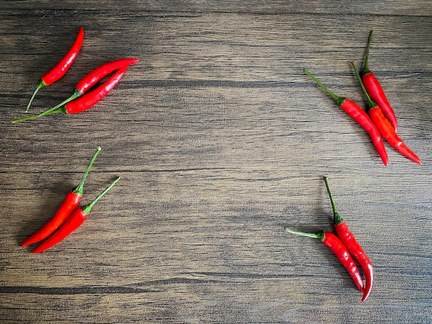 Fresh red chili and space for text on wooden background