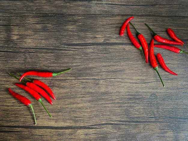 Fresh red chili and space for text on wooden background