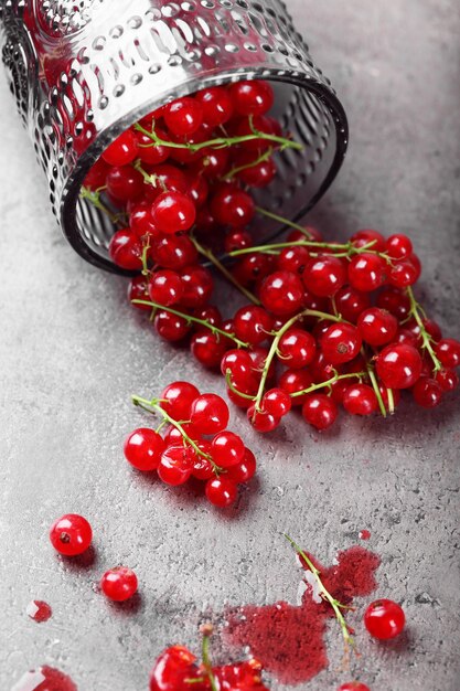 Fresh red currants in glass on table close up