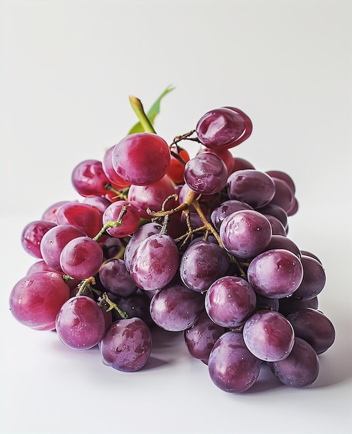 Fresh red grapes on a rustic surface surrounded by green leaves