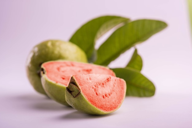 Fresh Red Guava fruit also known as Amrood in Hindi and Peru in Marathi, Served in a basket as a whole or slices over colourful background. Selective focus