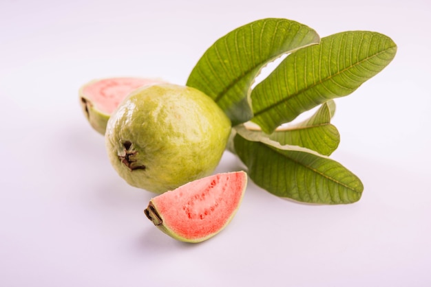 Fresh Red Guava fruit also known as Amrood in Hindi and Peru in Marathi, Served in a basket as a whole or slices over colourful background. Selective focus