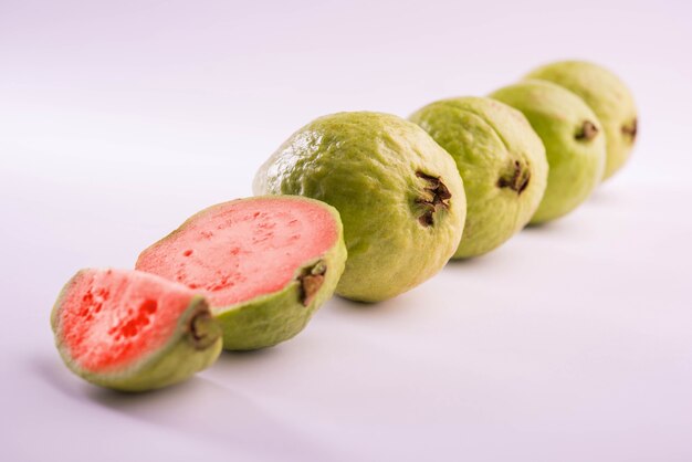 Fresh Red Guava fruit also known as Amrood in Hindi and Peru in Marathi, Served in a basket as a whole or slices over colourful background. Selective focus