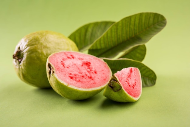 Fresh Red Guava fruit also known as Amrood in Hindi and Peru in Marathi, Served in a basket as a whole or slices over colourful background. Selective focus