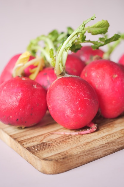 Fresh red radish bundle on chopping board on table