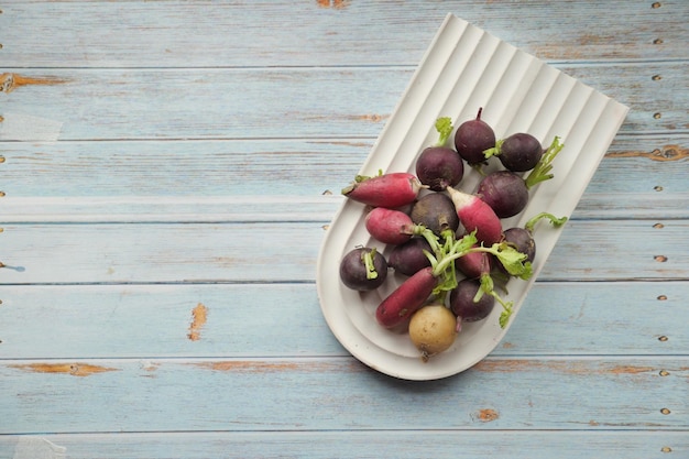 Fresh red radish bundle on chopping board on table