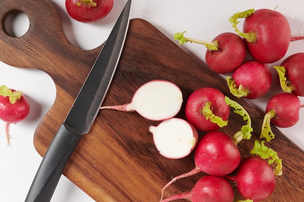 Fresh red radish on cutting board. Set of fresh whole small garden radish isolated on white surface. Top view. Flat lay. freshly picked from home growth organic garden. Food concept.