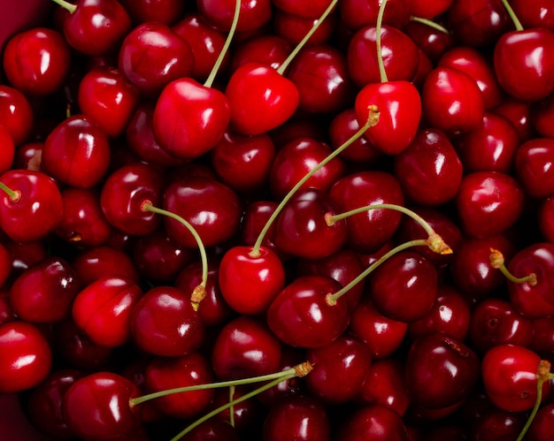 Fresh red ripe cherries with cuttings and leaves abundant background large collection of fresh red c